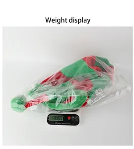 Close-up of Christmas red and green striped velvet long hat weighing 115.1g on scale
