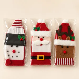 Nahaufnahme gestrickter Weihnachts-Weinflaschenhüllen mit Weihnachtsmann, Schneemann und Rentier.