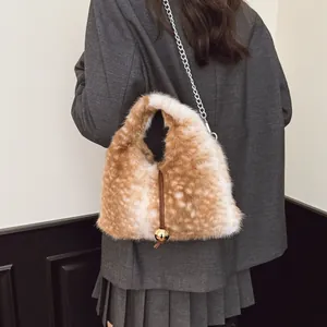 Detailansicht einer luxuriösen Kunstpelltasche mit Hirschprint und Goldanhänger.