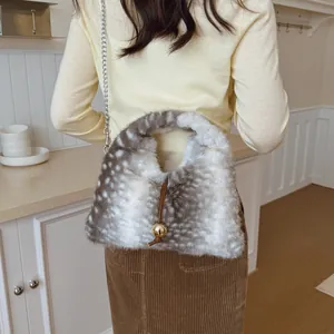 Stylische Umhängetasche aus Kunstpelz mit Hirschprint, getragen von einem Modell im Raum.