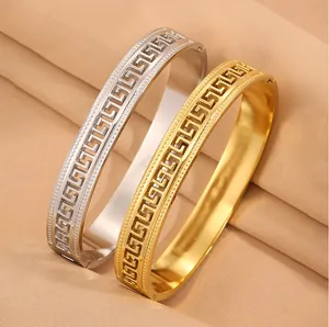 Detailed macro view of hollow Greek key pattern on stainless steel gold and silver bangles