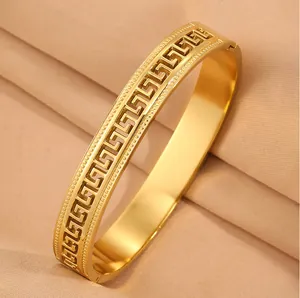 Detailed view of gold stainless steel bracelet with Greek key cutout pattern