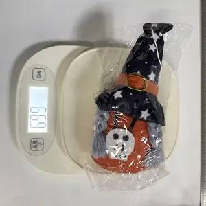 Halloween festive gnome plush doll weighing approximately 66.9 grams on a digital scale