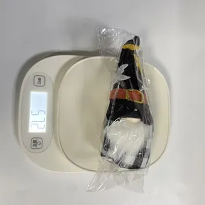 Halloween faceless gnome doll plush toy shown being weighed on a white digital scale at 57.2g