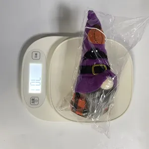 Macro view of Halloween gnome plush doll on digital scale showing weight measurement 70.1g