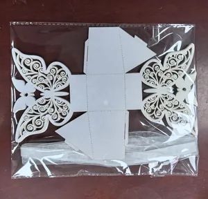 Detail of laser-cut white butterfly candy box flat-packed in clear plastic bag