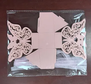 Detail view of a laser-cut butterfly wedding favor box in pink pearlescent paper