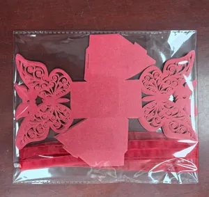 Flat packed laser-cut butterfly candy boxes with matching red ribbons in clear bag