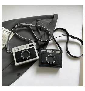 Vintage camera-shaped crossbody box bag with adjustable leather strap for women.