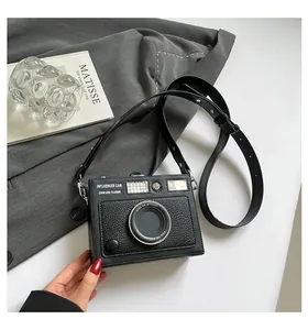 Close-up of a stylish vintage camera-shaped box bag featuring a detailed lens design.