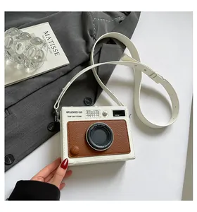 Close-up detail of a unique camera-shaped crossbody box bag with premium leather texture