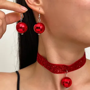 Primo piano di orecchini disco rossi e collana choker scintillante coordinata
