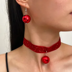 Dettaglio ravvicinato di un set girocollo e orecchini con ciondolo a sfera disco rossa