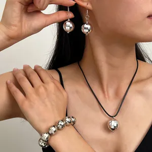 Set di gioielli con sfera disco argentata con orecchini collana e bracciale sulla modella