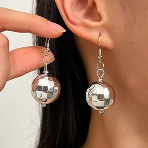 Primo piano di orecchini a palla da discoteca in argento con design sfaccettato