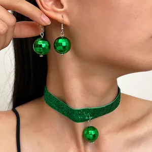 Dettaglio di orecchini a sfera disco verdi e set di collana girocollo glitterata su modella