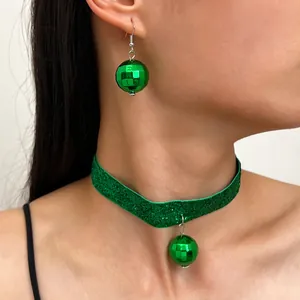 Dettaglio ravvicinato del choker glitterato verde e orecchini a palla disco lucidi