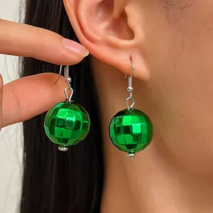 Dettaglio ravvicinato di orecchini a palla da discoteca verde brillante galvanizzati su orecchio