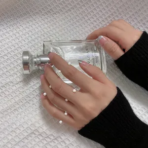 Detailansicht von minimalistischen Perlenringen, die auf der Hand eines Modells gestapelt sind.
