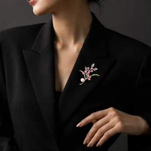 Detailed view of an elegant crystal flower brooch with pearl on a black blazer