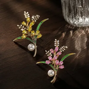 Detailed view of elegant wheat ear brooches with colorful crystals and lustrous pearls.