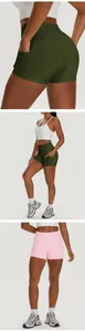 Detailed view of high-waisted yoga shorts with side pockets in olive green and pink