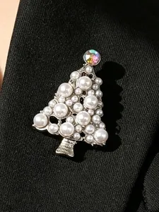 Nahaufnahme einer eleganten Weihnachtsbaumbrosche mit Perlen auf einem schwarzen Revers