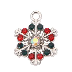 Vue rapprochée détaillée d'un pendentif flocon de neige scintillant aux pierres rouges et vertes.