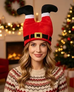 Beautiful woman wearing a plush red Christmas Santa legs hat in a festive home setting