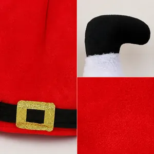 Close-up of Christmas elf hat featuring soft red plush fabric and shiny gold buckle detail.
