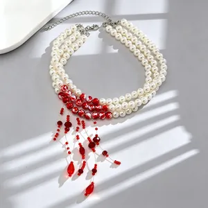 Detailed view of a triple-layer pearl necklace featuring red marble beads and tassels