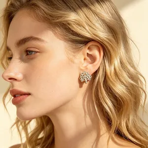 Gros plan d'une boucle d'oreille arbre de vie argentée sur un mannequin blond