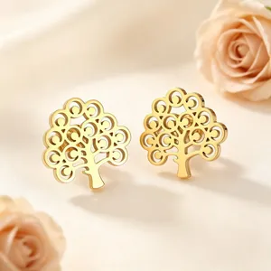 Gros plan exquis de boucles d'oreilles arbre de vie dorées sur soie avec des roses