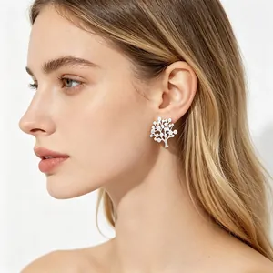Élégante boucle d'oreille arbre de vie en acier inoxydable portée par un mannequin