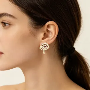 Vue détaillée d'une boucle d'oreille dorée en forme d'arbre portée par un modèle
