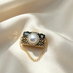 Detailweergave van een vintage camera-hanger met parellens en fonkelende strass-steentjes