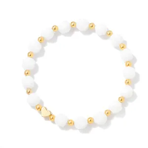 Detailed view of an elegant white faceted stone bead bracelet featuring a gold heart charm