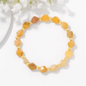 Elegant yellow faceted stone bead bracelet with a gold heart charm on white background.