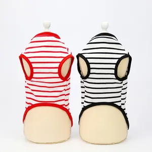 Detail view of two striped cotton pet dog vests in red and black on beige mannequins