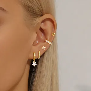 Detail showing elegant gold butterfly and star earring set with crystals on model's ear