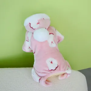Detailansicht eines weichen rosa Hunde-Fleece-Overalls mit weißer Bommelmütze für Hunde.