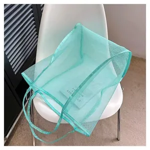 Vista dettagliata della borsa a rete verde menta con tessuto traspirante e manico