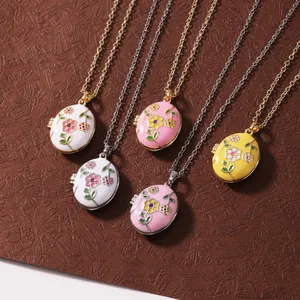 Detailopname van kleurrijke emaille bloemenmedaillons in wit, roze en geel.