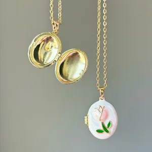 Close-up van een gouden ovaal medaillon met een elegant roze emaille tulpontwerp