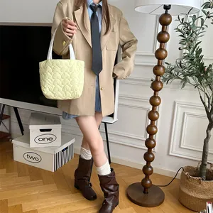 Süße hellgelbe gesteppte Herz-Einkaufstasche, präsentiert in einem lässigen Outfit-Detail