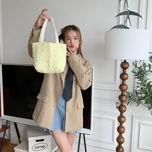 Süße gelbe gesteppte Herz Handtasche von einem Modell getragen, ideal für Uni
