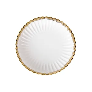 Elegant white ceramic plate with gold wavy rim and fluted texture for dining.