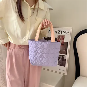 Detailaufnahme einer lavendelfarbenen Stepptasche mit süßem Herzmuster.