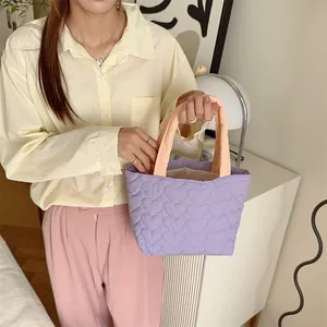 Nahaufnahme einer niedlichen gesteppten lavendelfarbenen Tasche mit Herzmuster am Modell