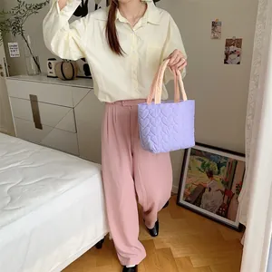 Nahaufnahme einer violetten gesteppten Handtasche mit Herzmuster in einer hellen Wohnumgebung